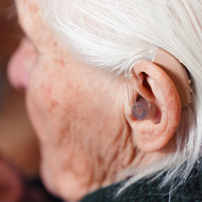 Photo of an older person wearing a hearing aid